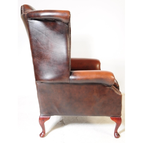 932 - Chesterfield style - A 20th Century brown leather Chesterfield manner wingback armchair. Raised on c... 