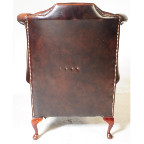 932 - Chesterfield style - A 20th Century brown leather Chesterfield manner wingback armchair. Raised on c... 