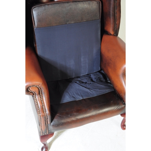 932 - Chesterfield style - A 20th Century brown leather Chesterfield manner wingback armchair. Raised on c... 