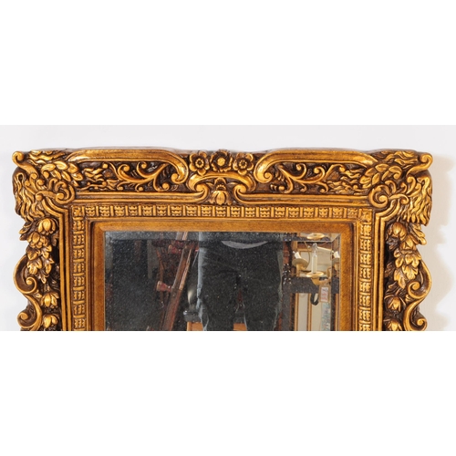 942 - A 20th century Indian manner gilt framed wall mirror. The mirror having carved gilt frame, featuring... 