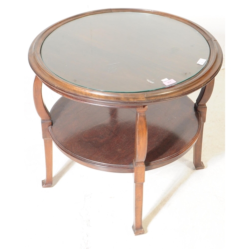 954 - An early 20th century oak wood round two tier coffee table. The coffee table having an inset circula... 