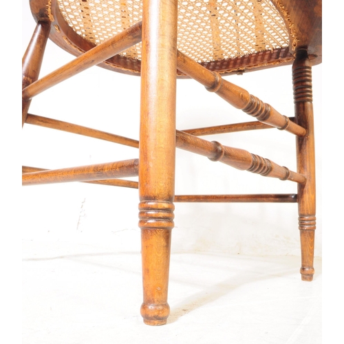 956 - A 19th century Victorian oak and rattan smokers bow captains armchair. The chair raised on rounded s... 