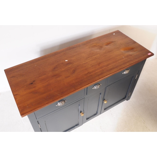 973 - A 20th century painted country pine sideboard. Rectangular form with solid wood top, panel sides and... 