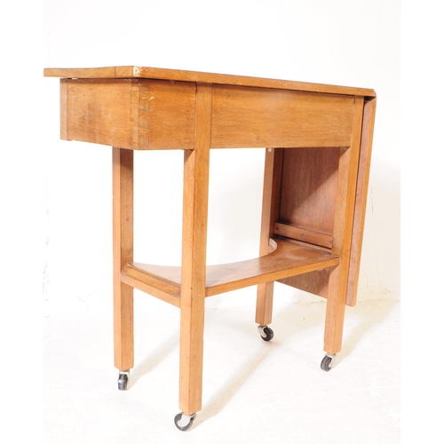 979 - A vintage 20th century oak sewing / side table. With small needle / thread drawer, with gate leg ext... 