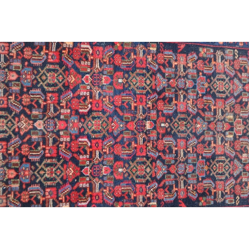 1037 - A late 19th century Persian Iranian Hamadan carpet floor rug. The rug having a red ground with black... 