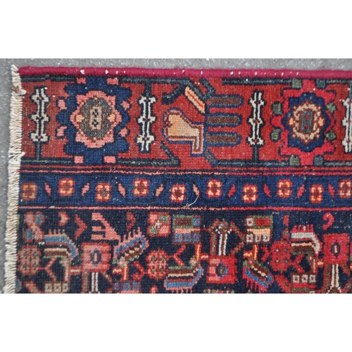 1037 - A late 19th century Persian Iranian Hamadan carpet floor rug. The rug having a red ground with black... 