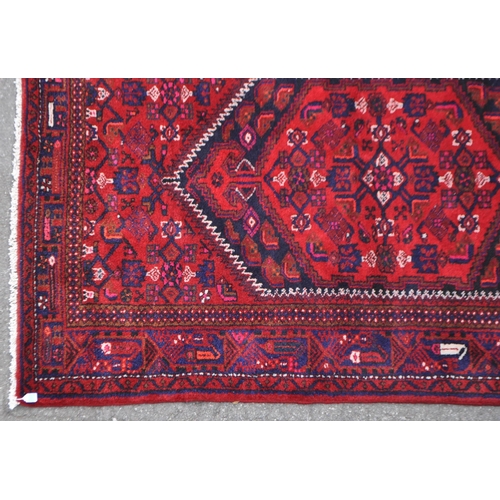 1038 - A mid 20th century Persian Malayer hand knotted carpet floor rug. The rug having a red ground with d... 