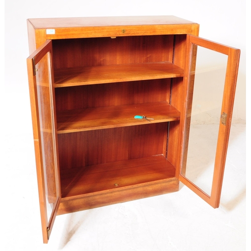 673 - British Modern Design - A mid 20th century walnut glazed display cabinet / bookcase. The cabinet hav... 