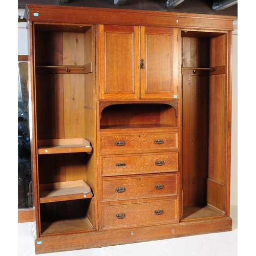 967 - A large Edwardian oak wood compactum wardrobe. Of rectangular form with bank of drawers to centre wi... 