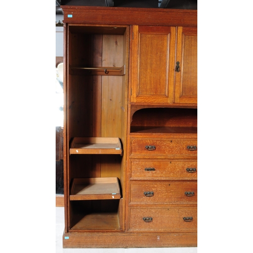 967 - A large Edwardian oak wood compactum wardrobe. Of rectangular form with bank of drawers to centre wi... 