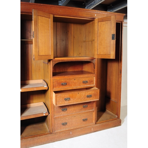 967 - A large Edwardian oak wood compactum wardrobe. Of rectangular form with bank of drawers to centre wi... 