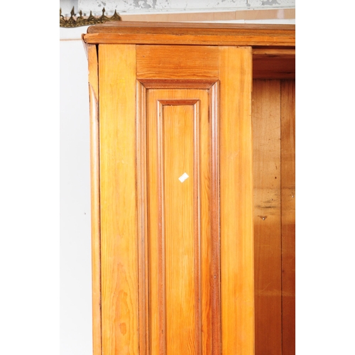 968 - A 19th century Victorian pine wardrobe. The wardrobe having pediment to top over central mirrored do... 