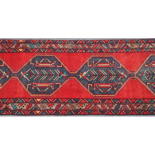 977 - A 20th century North West Persian Hamadan carpet runner floor rug. The rug having a red ground, with... 