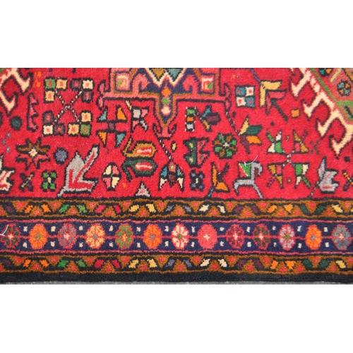 982 - A 20th century North West Persian Heriz runner carpet floor rug. Having a red central field populate... 