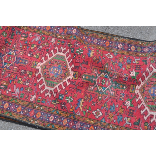 982 - A 20th century North West Persian Heriz runner carpet floor rug. Having a red central field populate... 