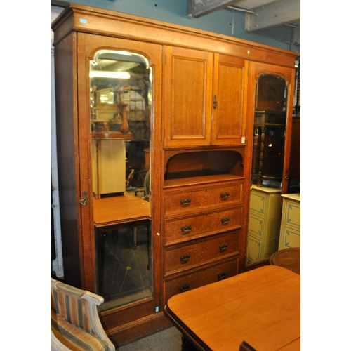 967 - A large Edwardian oak wood compactum wardrobe. Of rectangular form with bank of drawers to centre wi... 