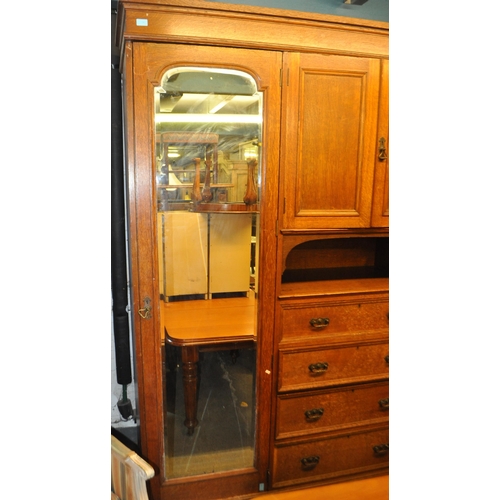 967 - A large Edwardian oak wood compactum wardrobe. Of rectangular form with bank of drawers to centre wi... 