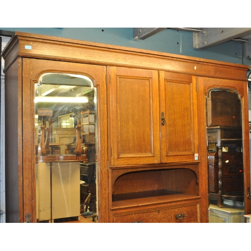 967 - A large Edwardian oak wood compactum wardrobe. Of rectangular form with bank of drawers to centre wi... 