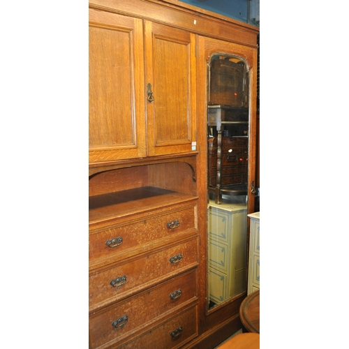 967 - A large Edwardian oak wood compactum wardrobe. Of rectangular form with bank of drawers to centre wi... 