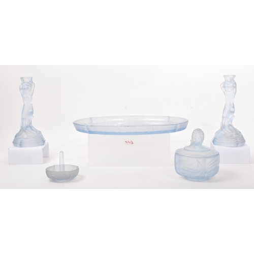 26 - An Art Deco blue glass dressing table set with floral scroll decoration, the candlesticks with merma... 