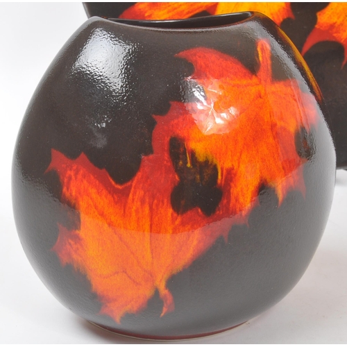 31 - Poole Pottery - A forest flame purse table top vase, together with matching pattern large wall / dis... 