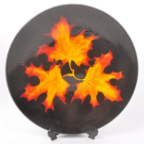 31 - Poole Pottery - A forest flame purse table top vase, together with matching pattern large wall / dis... 