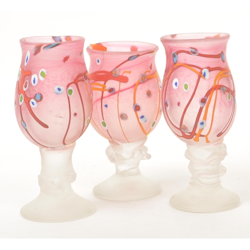38 - A set of three 20th century studio art glass hand blown stemmed glasses. Each glass raised on a roun... 