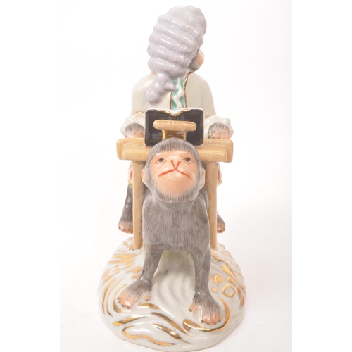 47 - Two 20th century Meissen manner porcelain monkey figures. One figure depicting a monkey stood, with ... 