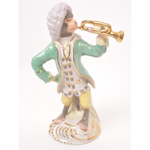 47 - Two 20th century Meissen manner porcelain monkey figures. One figure depicting a monkey stood, with ... 