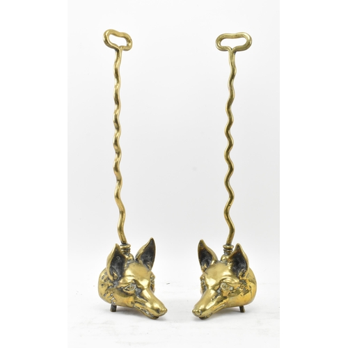 259 - A pair of Victorian 19th century brass fox head door stops. Each with a handle atop over a central b... 