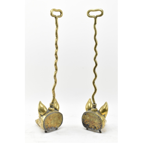 259 - A pair of Victorian 19th century brass fox head door stops. Each with a handle atop over a central b... 