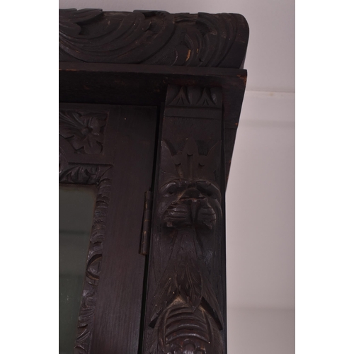 292 - A Victorian 19th century carved oak library bookcase. The cabinet top having two glazed doors flanke... 