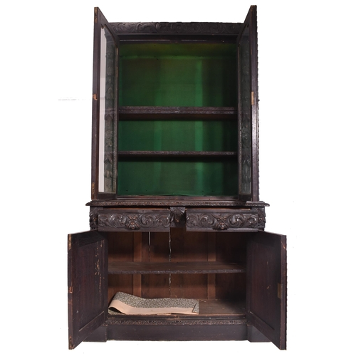 292 - A Victorian 19th century carved oak library bookcase. The cabinet top having two glazed doors flanke... 