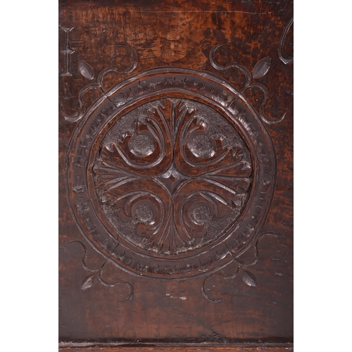 296 - An 17th century carved oak country coffer chest. The coffer having a three panelled hinged top over ... 