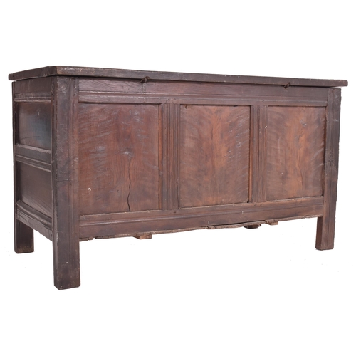 296 - An 17th century carved oak country coffer chest. The coffer having a three panelled hinged top over ... 