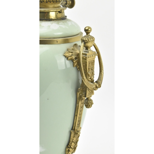 396 - A late 19th century / early 20th century gilt metal mounted pâte sur pâte celadon ceramic desk lamp ... 