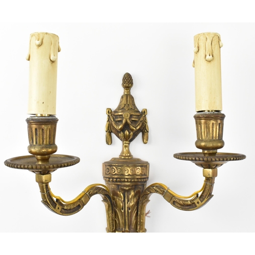 407 - A matching set of four 20th century gilt metal wall light sconces. Each with decorative urn and swag... 