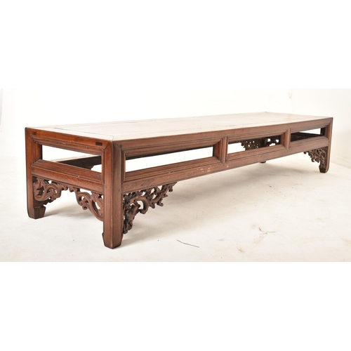 416 - A large Oriental Chinese influenced carved hardwood low occasional side table. The table having a re... 