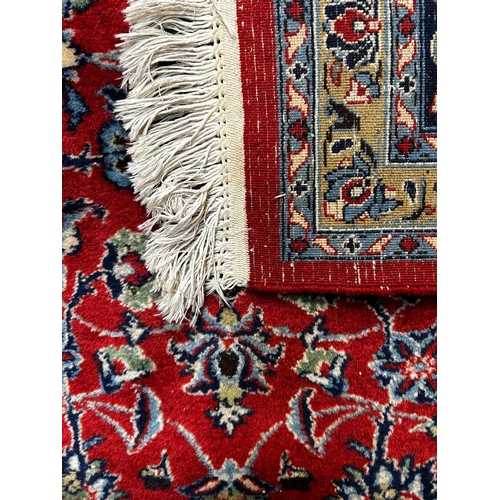 417 - A 20th century Islamic Sarouk Bakhtiyar floor carpet rug. The rug having a central red ground panel ... 