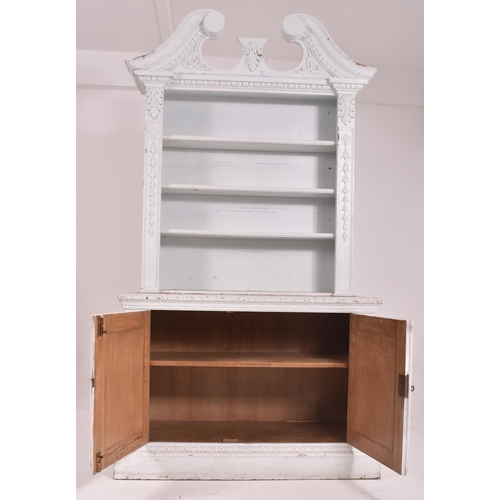 432 - A Victorian early 19th century white painted pine wood library bookcase. The bookcase having a scrol... 