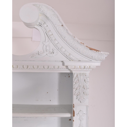 432 - A Victorian early 19th century white painted pine wood library bookcase. The bookcase having a scrol... 