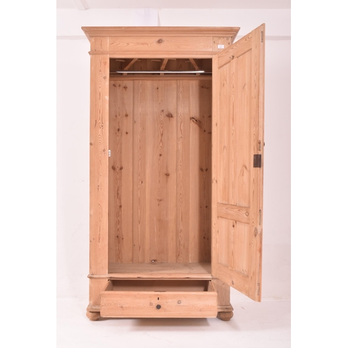 442 - A 20th century Scandinavian sentry box / pine single wardrobe armoire. The wardrobe being raised on ... 