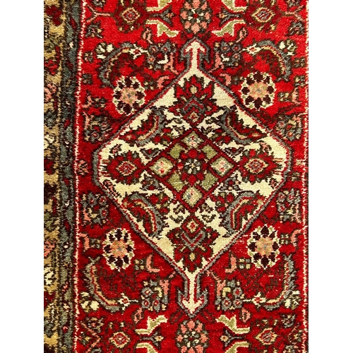 459 - An early 20th century Persian Islamic Bijar floor carpet runner rug. The runner having a red ground ... 