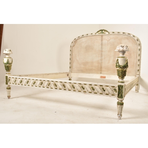 471 - A French Louis XVI inspired painted double cane bed frame. The bed having a cane paneled headboard w... 