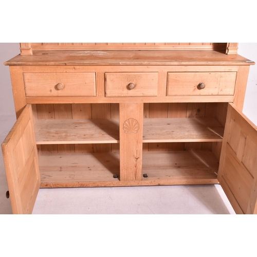 496 - A 20th century pine country farmhouse Welsh dresser. The dresser having flared pediment atop with fi... 