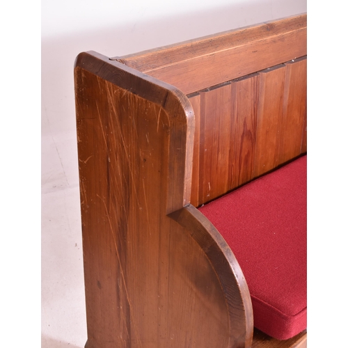 498 - An early 20th century pine ecclesiastic church pew settle bench. The bench having a panelled back wi... 