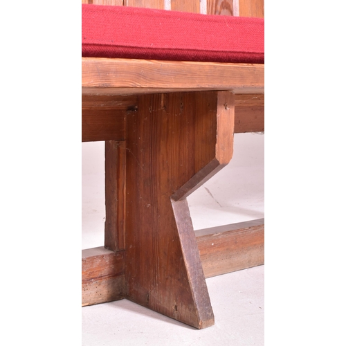 498 - An early 20th century pine ecclesiastic church pew settle bench. The bench having a panelled back wi... 