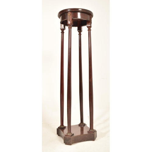 523 - A Biedermeier continental 19th century mahogany torchere / plant stand. The stand having a circular ... 