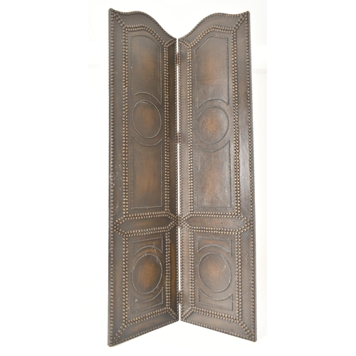 553 - A vintage 20th century mahogany & studded leather two fold discretion screen. The screen featuring c... 