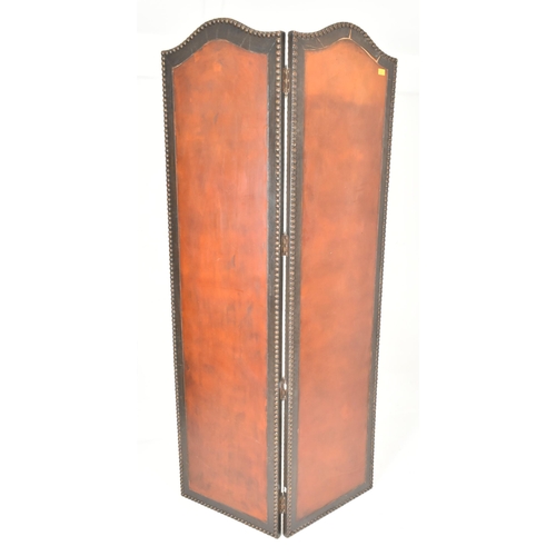 553 - A vintage 20th century mahogany & studded leather two fold discretion screen. The screen featuring c... 